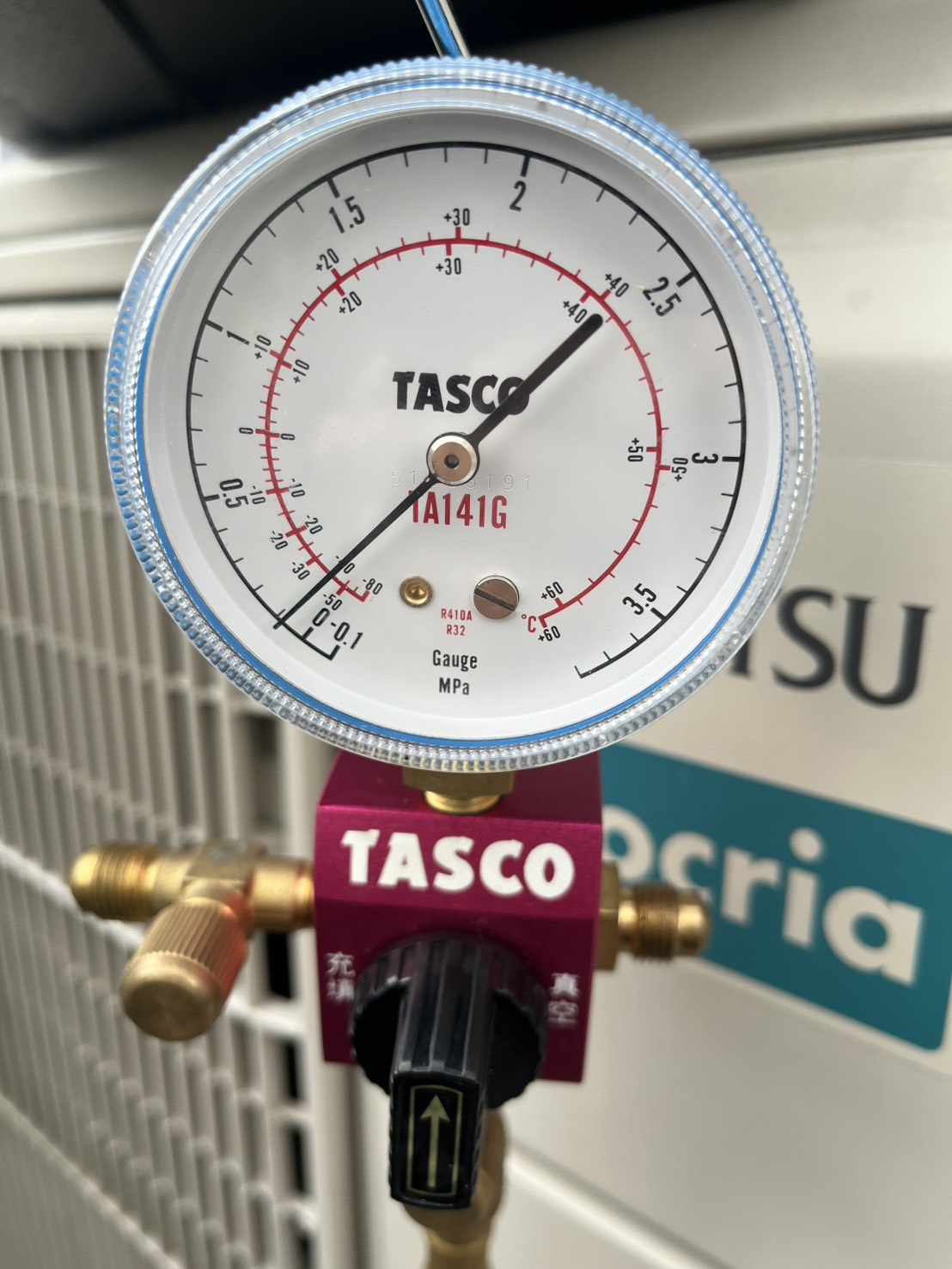 室外機前でTASCOのアナログゲージとバルブを接続している様子
